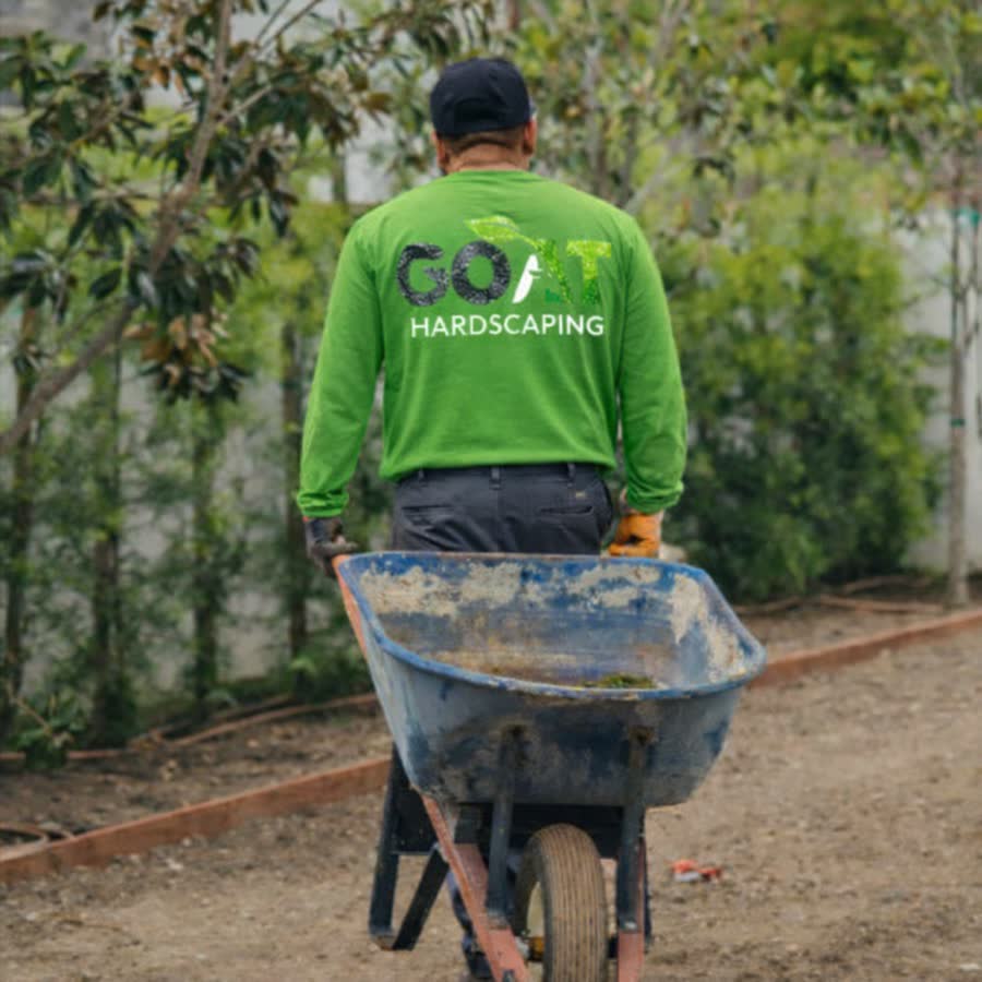 GOAT crew member with a wheelbarrow on a job site